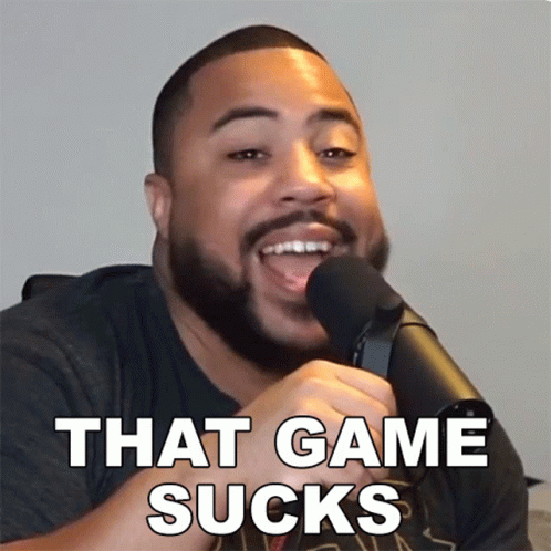 A Man With A Beard Is Talking Into A Microphone With The Words That Game Sucks Below Him GIF