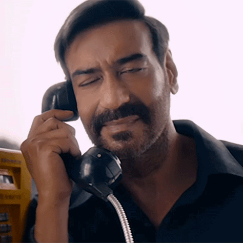 A Man With A Beard Is Talking On A Phone With A Yellow Box In The Background GIF