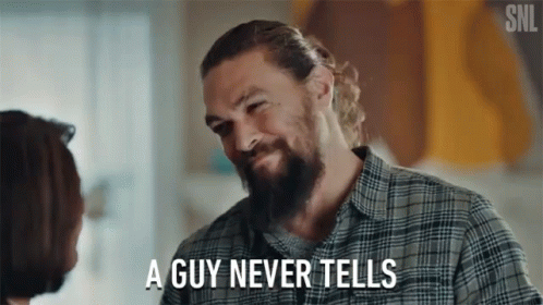 A Man With A Beard Is Talking To A Woman And Says " A Guy Never Tells " GIF