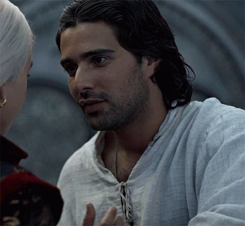 A Man With A Beard Is Talking To A Woman . GIF