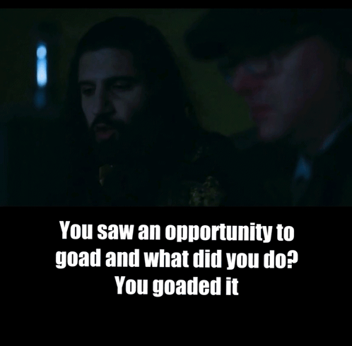 A Man With A Beard Is Talking To Another Man In A Dark Room GIF
