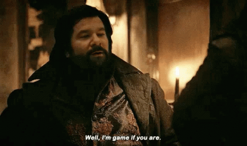 A Man With A Beard Is Talking To Another Man In A Room With A Candle . GIF
