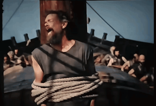 A Man With A Beard Is Tied Up With A Rope And Screaming GIF