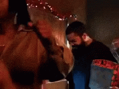 A Man With A Beard Is Touching Another Man 'S Face GIF