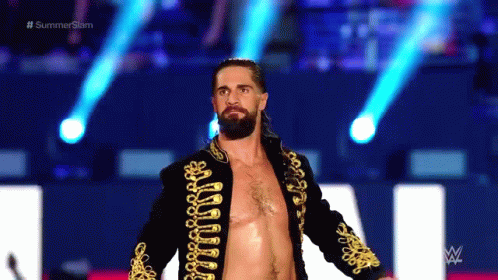 A Man With A Beard Is Walking On A Stage Without A Shirt On . GIF