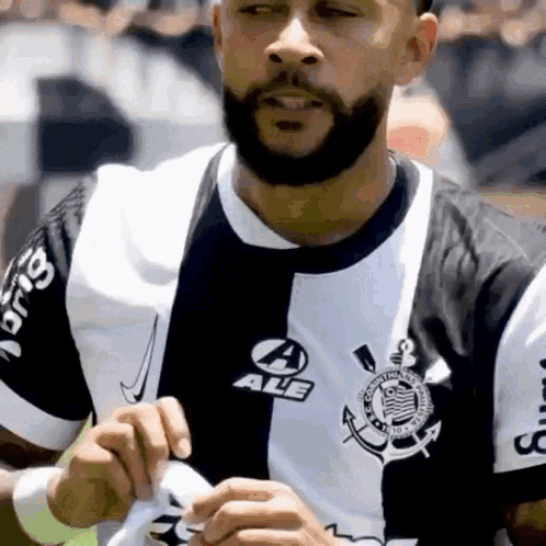 A Man With A Beard Is Wearing A Black And White Shirt That Says Ale GIF