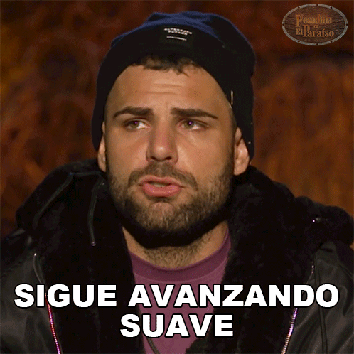 A Man With A Beard Is Wearing A Black Beanie And A Purple Shirt With The Words Sigue Avanzando Suave Below Him GIF