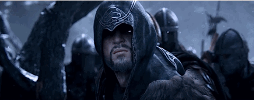 a man with a beard is wearing a black hooded jacket .