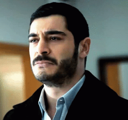 A Man With A Beard Is Wearing A Black Jacket GIF