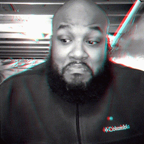 A Man With A Beard Is Wearing A Black Jacket That Says Columbia GIF