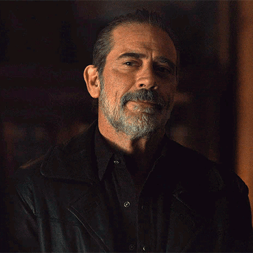 A Man With A Beard Is Wearing A Black Shirt And A Leather Jacket GIF