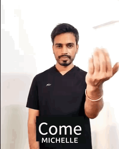 A Man With A Beard Is Wearing A Black Shirt And Giving A Middle Finger . GIF