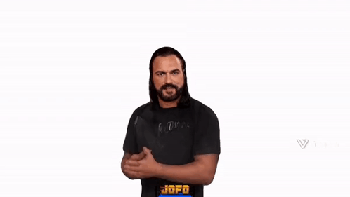 A Man With A Beard Is Wearing A Black Shirt And Giving A Thumbs Up Sign . GIF