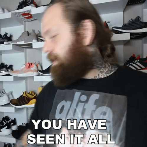 A Man With A Beard Is Wearing A Black Shirt That Says Alife GIF