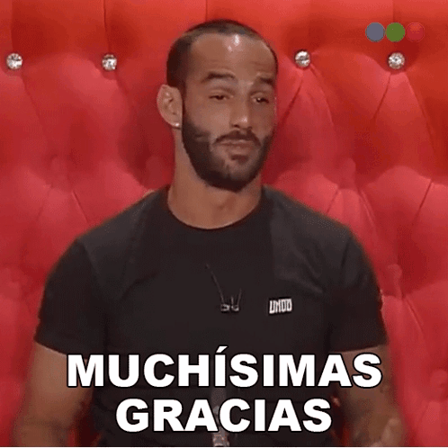 A Man With A Beard Is Wearing A Black Shirt That Says Muchisimas Gracias On It GIF