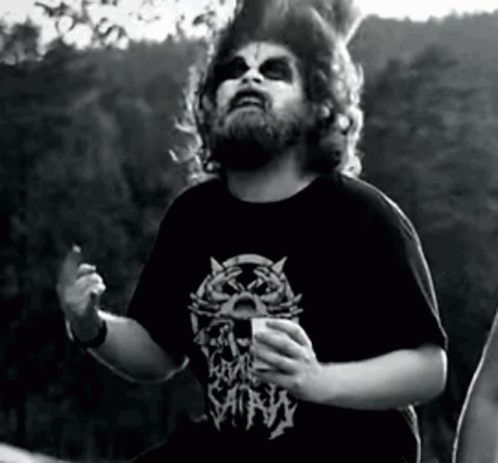 A Man With A Beard Is Wearing A Black Shirt With A Cat On It And The Word Satan On It GIF