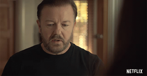 A Man With A Beard Is Wearing A Black Shirt With A Netflix Logo On The Bottom GIF