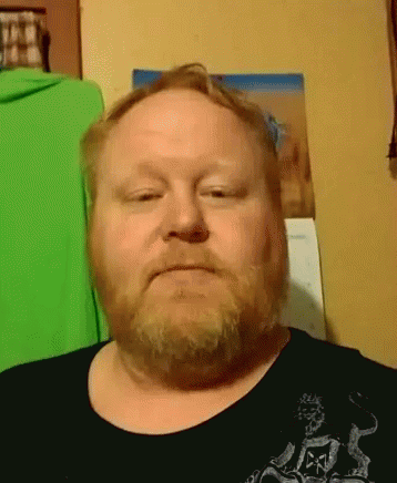 A Man With A Beard Is Wearing A Black Shirt With A Skull And Crossbones On It GIF