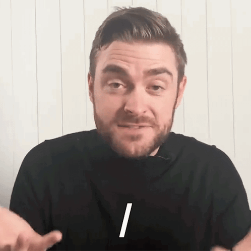 A Man With A Beard Is Wearing A Black Shirt With The Letter I On The Front GIF