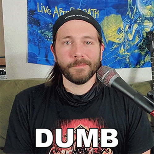 A Man With A Beard Is Wearing A Black Shirt With The Word Dumb On It GIF