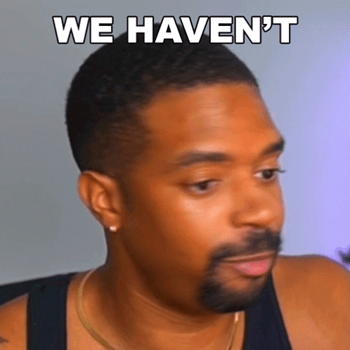 A Man With A Beard Is Wearing A Black Tank Top And Has The Words " We Haven 'T " Written On His Face GIF