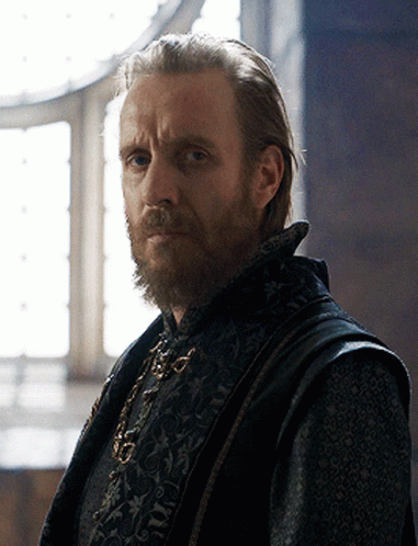 a man with a beard is wearing a black vest with a floral pattern