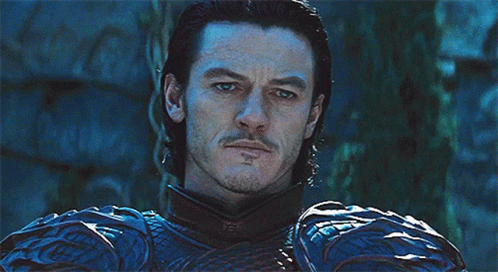 A Man With A Beard Is Wearing A Blue And Black Armor GIF