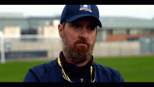 A Man With A Beard Is Wearing A Blue Hat That Says ' Ireland ' On It GIF