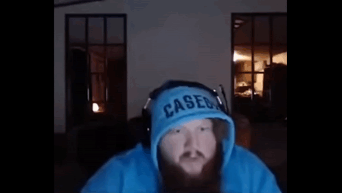 A Man With A Beard Is Wearing A Blue Hoodie And Headphones And Says `` Yo What ? '' GIF