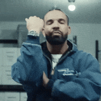 A Man With A Beard Is Wearing A Blue Jacket With The Letter T On It GIF