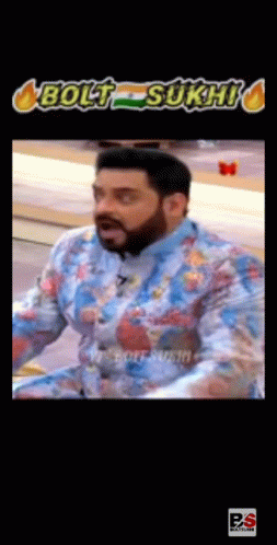 A Man With A Beard Is Wearing A Blue Shirt With A Floral Pattern And Making A Funny Face . GIF