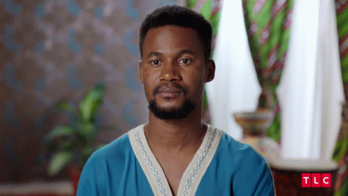 A Man With A Beard Is Wearing A Blue Shirt With The Letters Tlc On It GIF