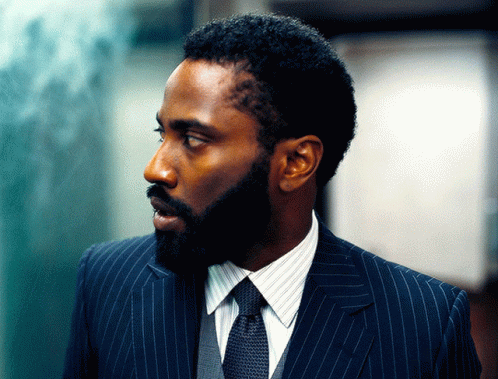 A Man With A Beard Is Wearing A Blue Suit And Tie GIF
