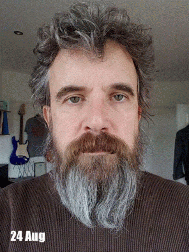 A Man With A Beard Is Wearing A Brown Sweater And The Date 24 Aug GIF