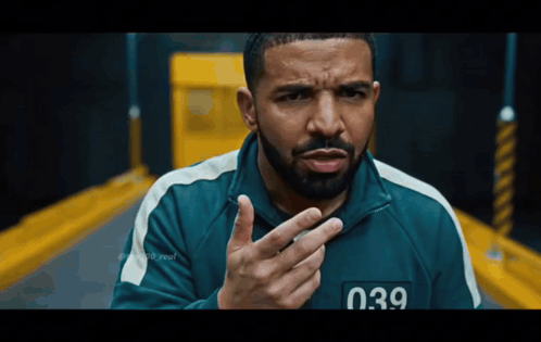 A Man With A Beard Is Wearing A Green Jacket With The Number 039 On The Front GIF