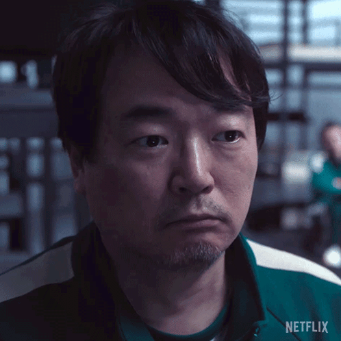 A Man With A Beard Is Wearing A Green Netflix Shirt . GIF