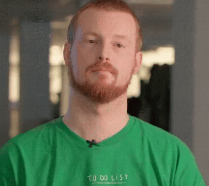 a man with a beard is wearing a green t-shirt that says to do list