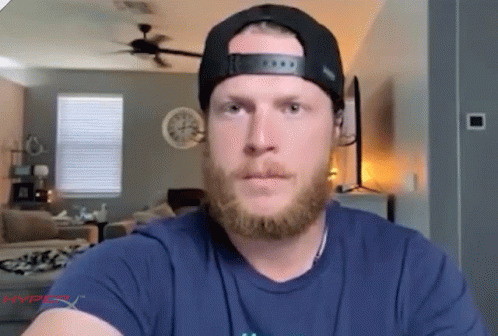 A Man With A Beard Is Wearing A Hat And A Blue Shirt That Says Hyperx On It GIF