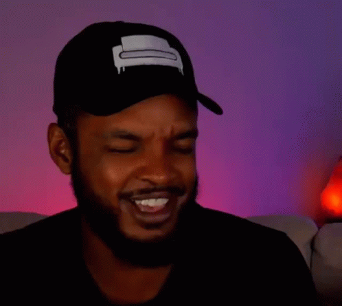 A Man With A Beard Is Wearing A Hat And Making A Funny Face With His Eyes Closed . GIF