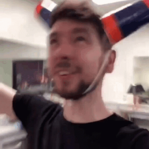 A Man With A Beard Is Wearing A Hat Made Out Of A Bottle . GIF