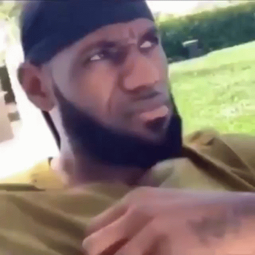 A Man With A Beard Is Wearing A Headband And A Bandana . GIF