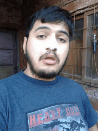 A Man With A Beard Is Wearing A Heavy Duty T-Shirt GIF