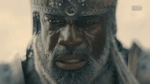 A Man With A Beard Is Wearing A Helmet With A Dragon On It GIF
