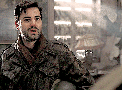 A Man With A Beard Is Wearing A Jacket And Scarf And Holding A Helmet GIF