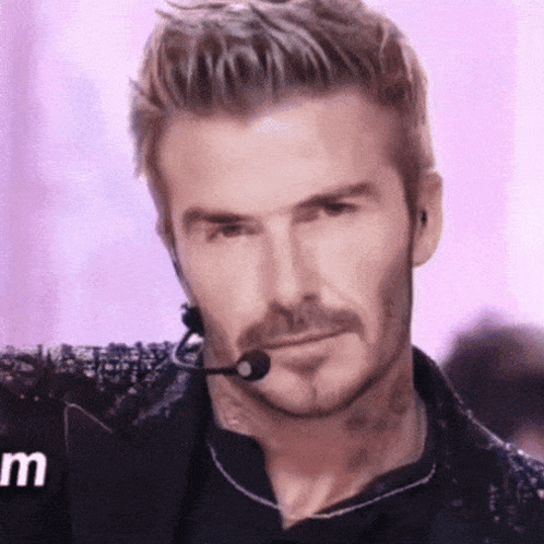 A Man With A Beard Is Wearing A Microphone And Headphones . GIF