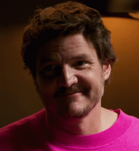 A Man With A Beard Is Wearing A Pink Sweater And Smiling GIF