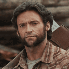 A Man With A Beard Is Wearing A Plaid Shirt And Carrying A Brown Wallet GIF