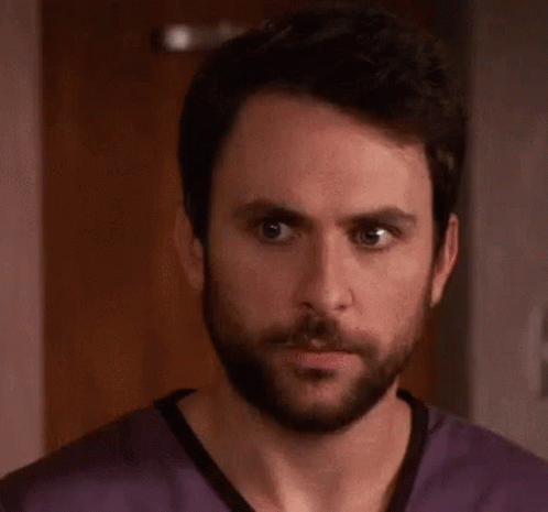 A Man With A Beard Is Wearing A Purple Scrub Top And The Word Rape Is Written On His Face . GIF