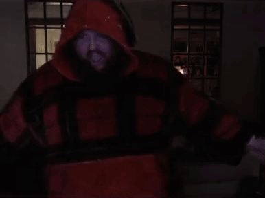 A Man With A Beard Is Wearing A Red And Black Jacket With The Letter H On The Front GIF