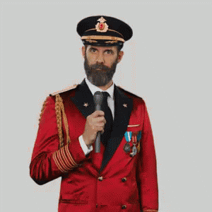 A Man With A Beard Is Wearing A Red Suit And Hat And Making A Funny Face . GIF